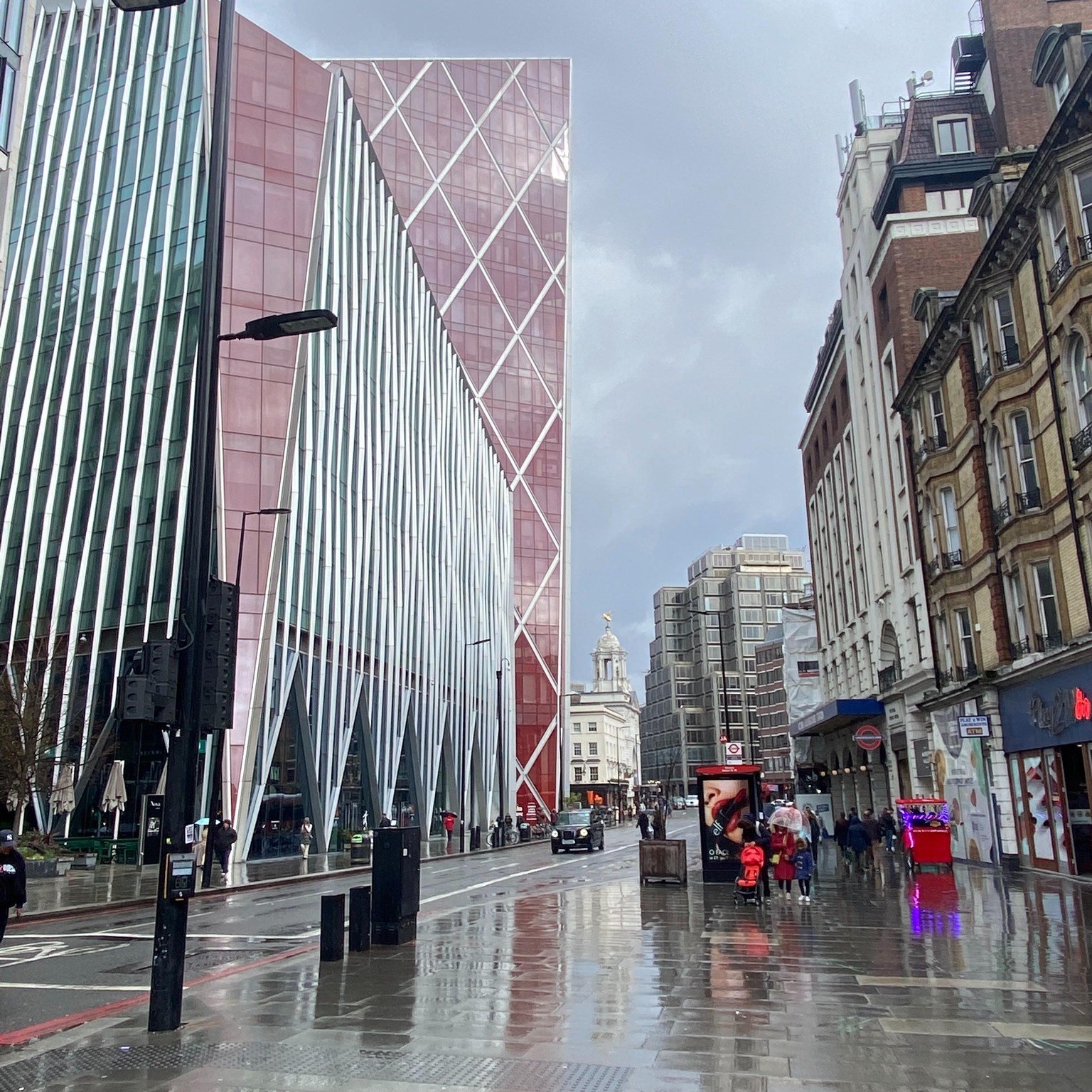 Shiny Pimlico London street reflecting red paneled high rise building. 