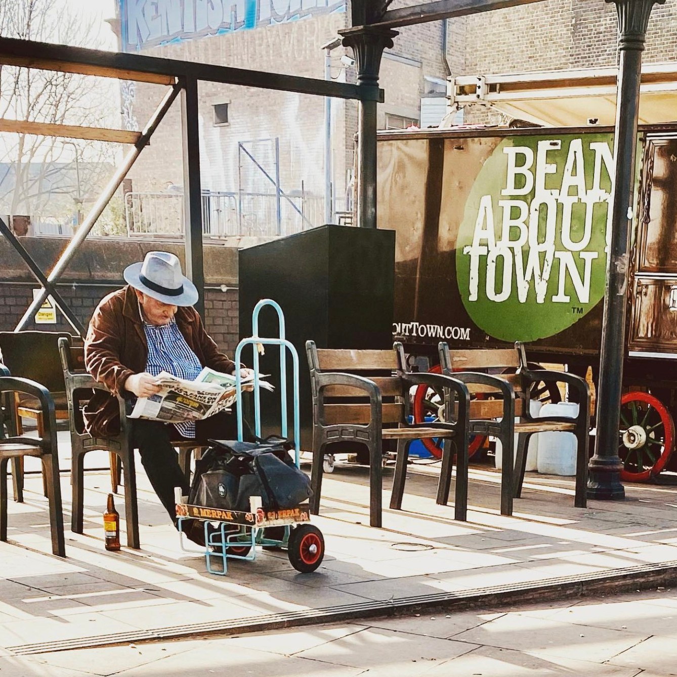 Man sitting on bench reading paper
