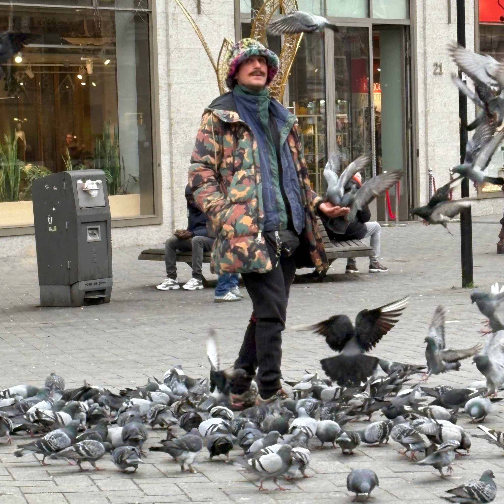Man feeding pigeons in Amsterdam